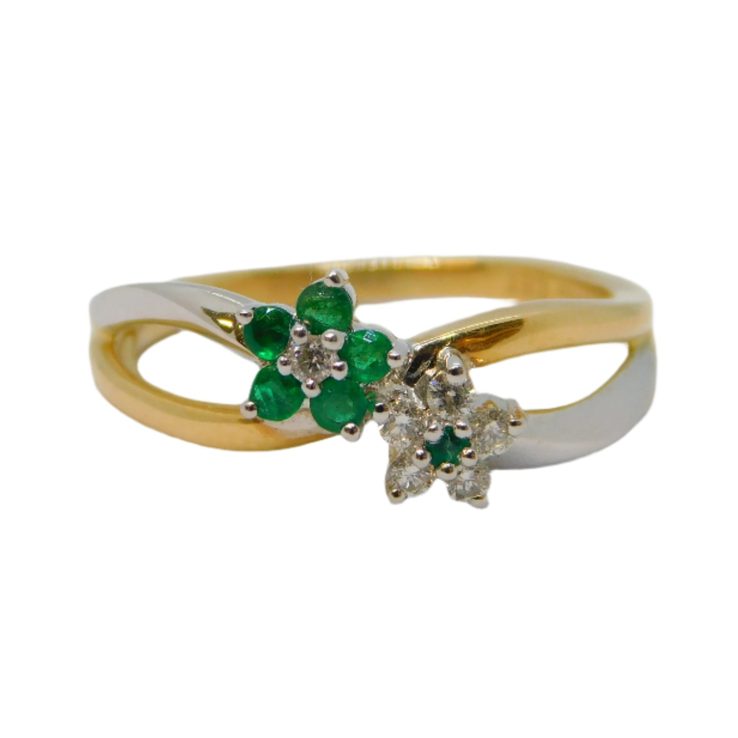 Gold ring with emerald and diamond accents on a light gray background