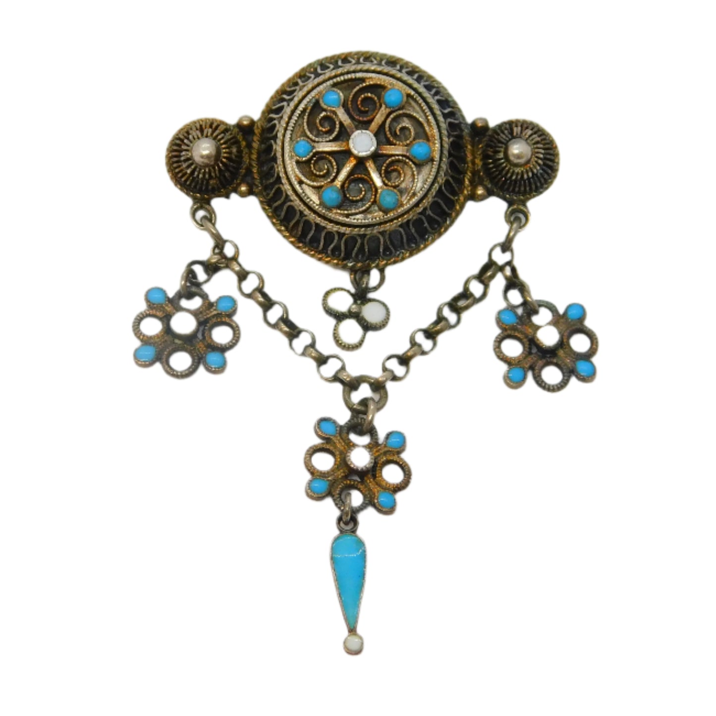 Decorative brooch with turquoise stones and floral designs on a white background