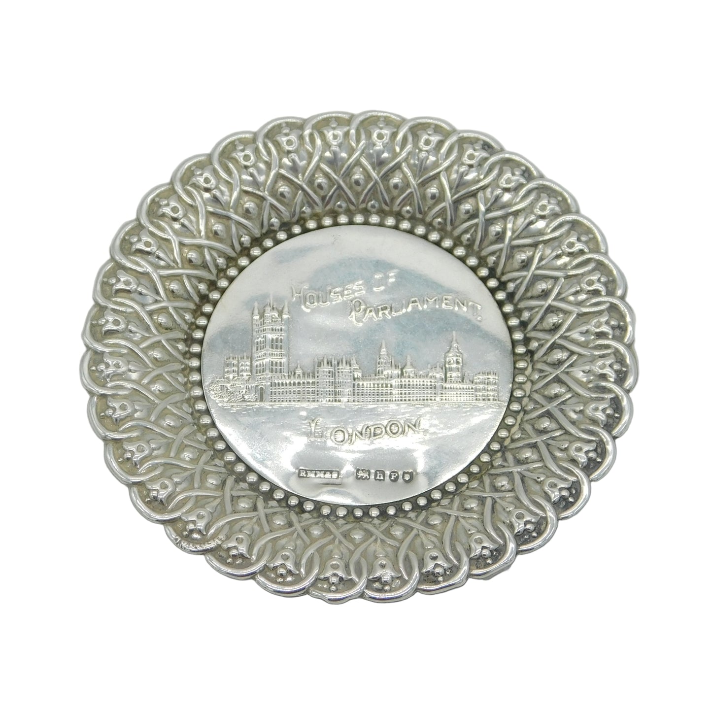 Decorative silver plate with intricate patterns and a central emblem on a white background