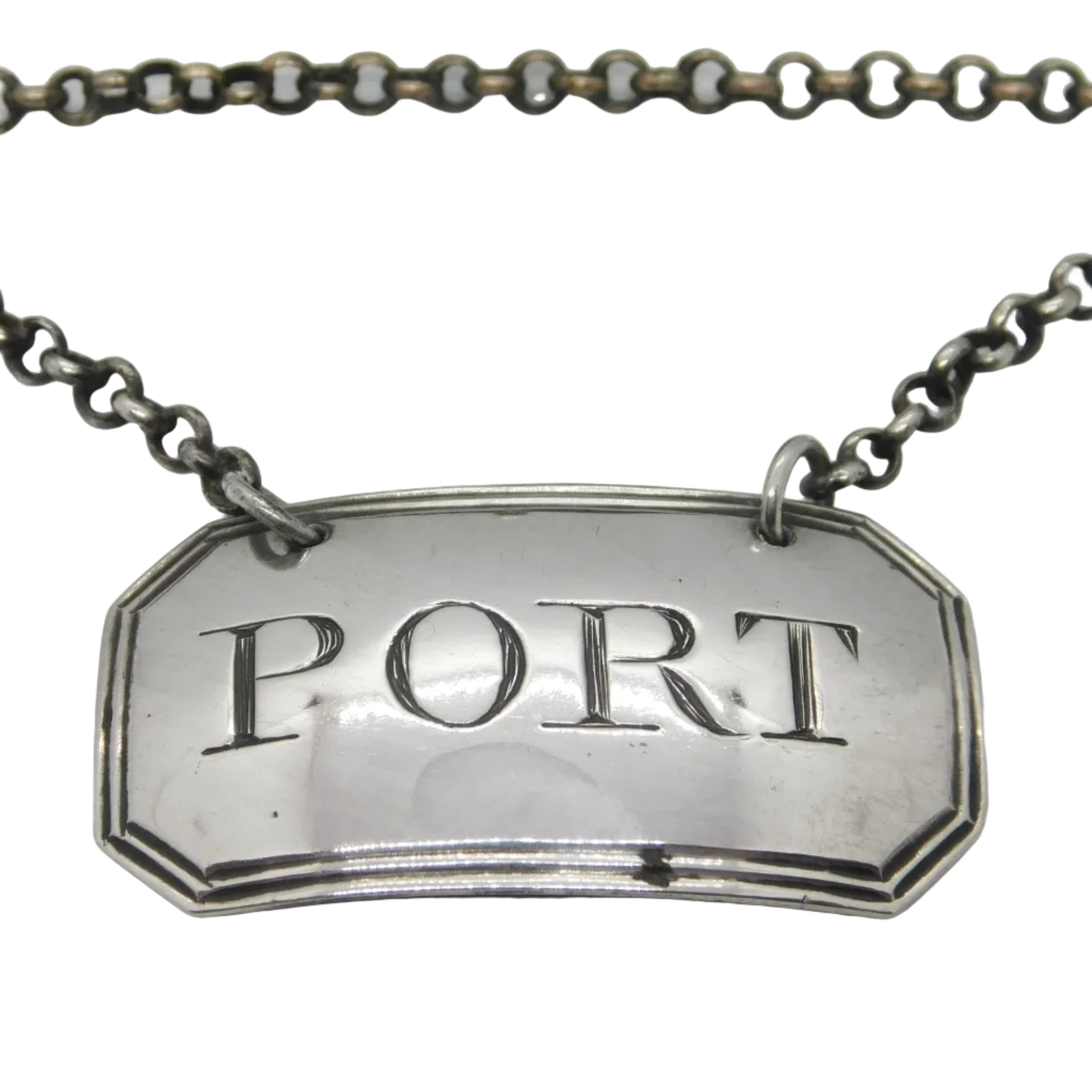 Antique sterling silver bright cut port decanter label with 'PORT' engraved in bold, mounted on a chain.