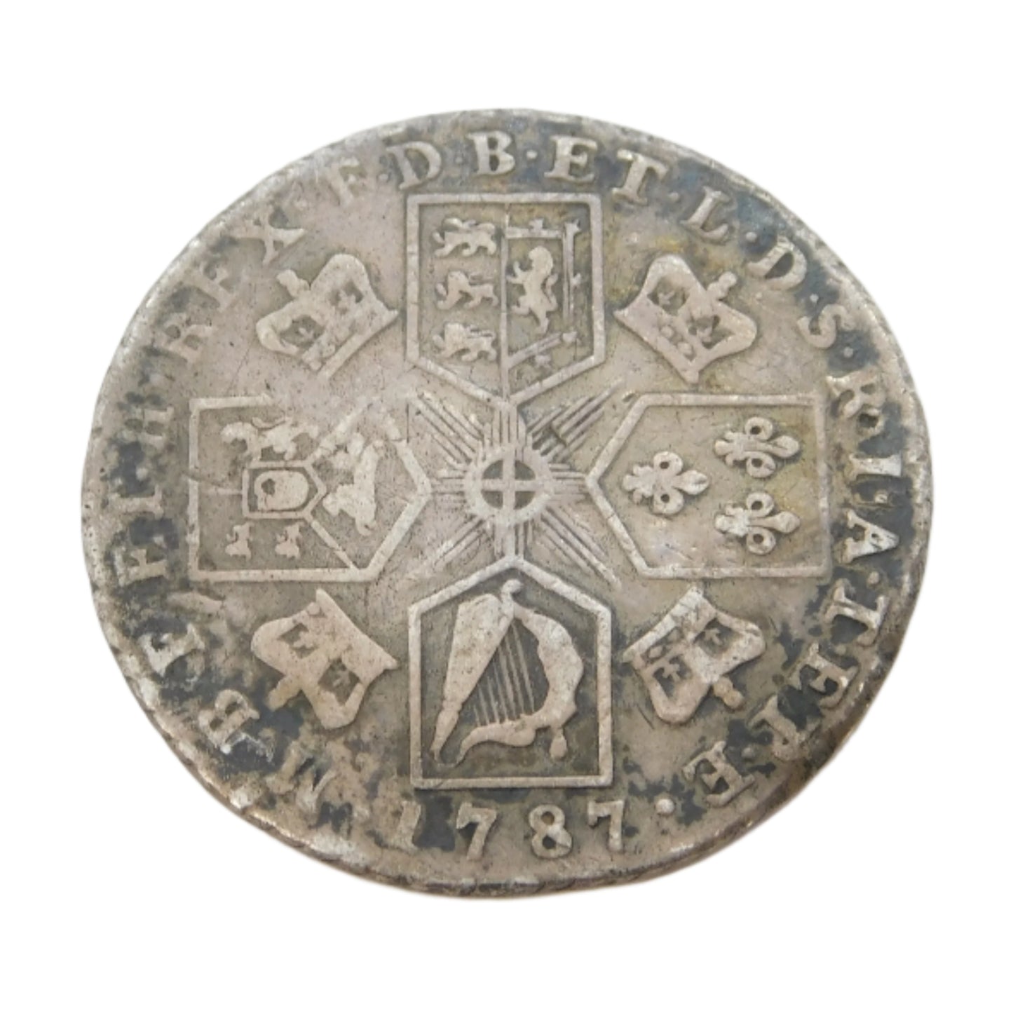Old silver coin with intricate designs on a white background