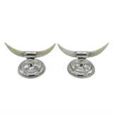 Two silver candle holders with long white horns on a light gray background