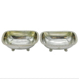 Two silver salt shakers on a white background