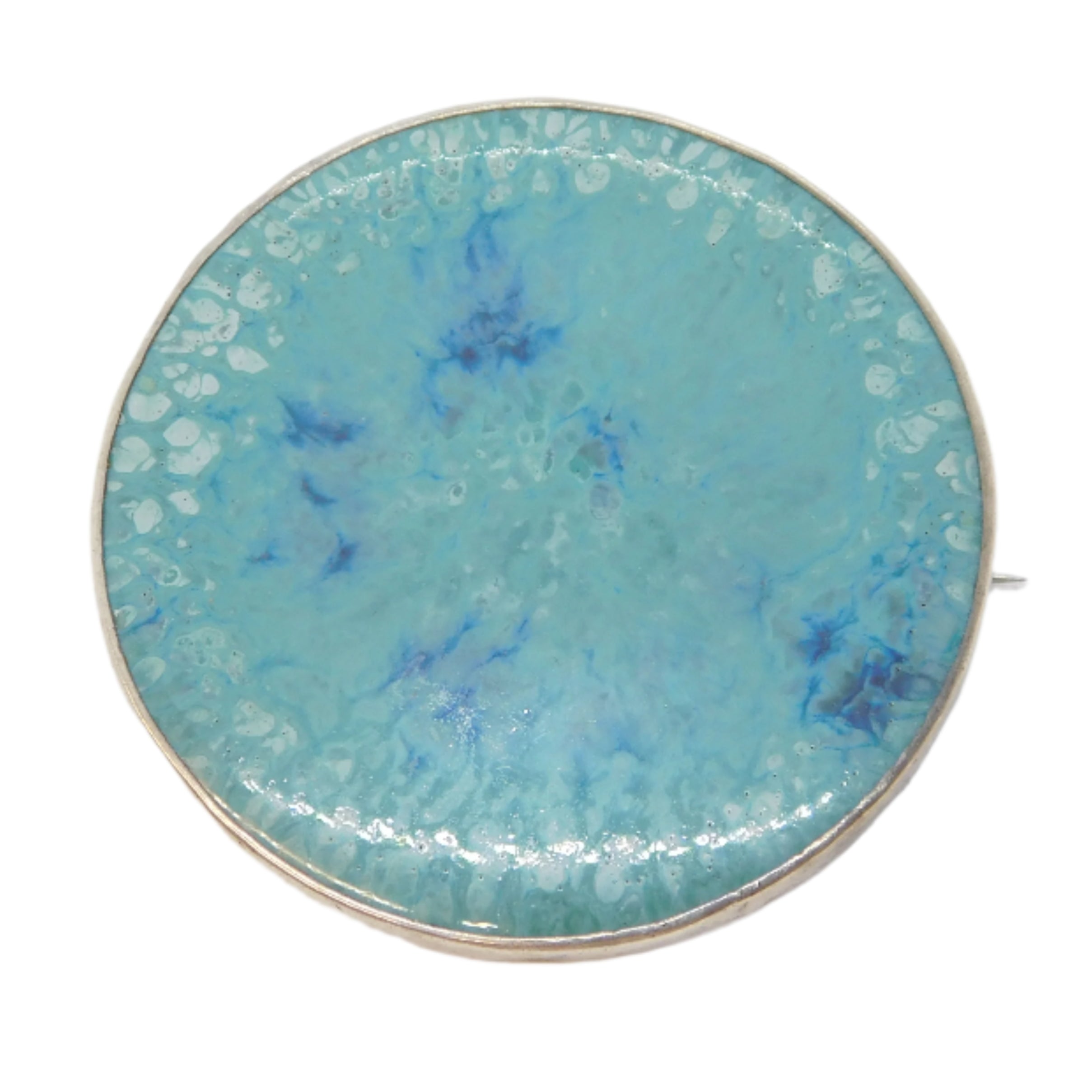 Round turquoise brooch with gold edge on a white background