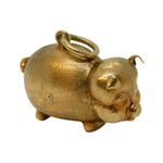 Gold pig-shaped charm on a white background