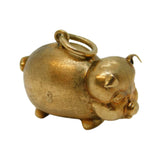 Gold pig-shaped charm on a white background