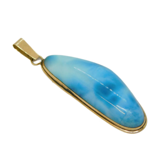 Blue pendant with gold setting on a light gray background