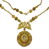 Gold necklace with intricate pendant on a white background