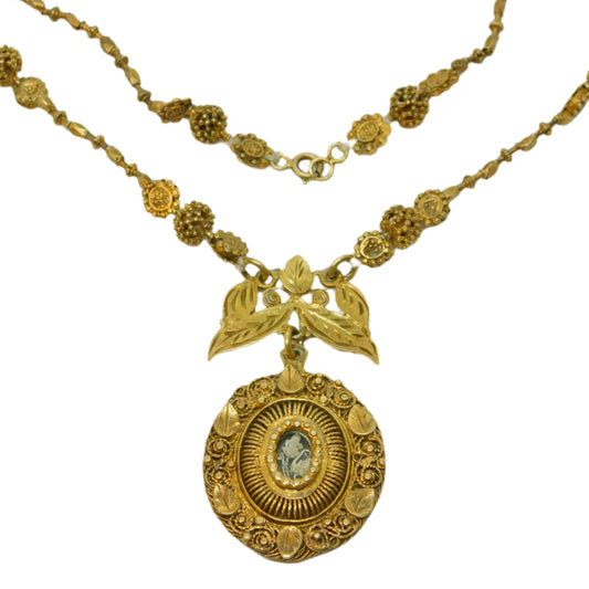 Gold necklace with intricate pendant on a white background
