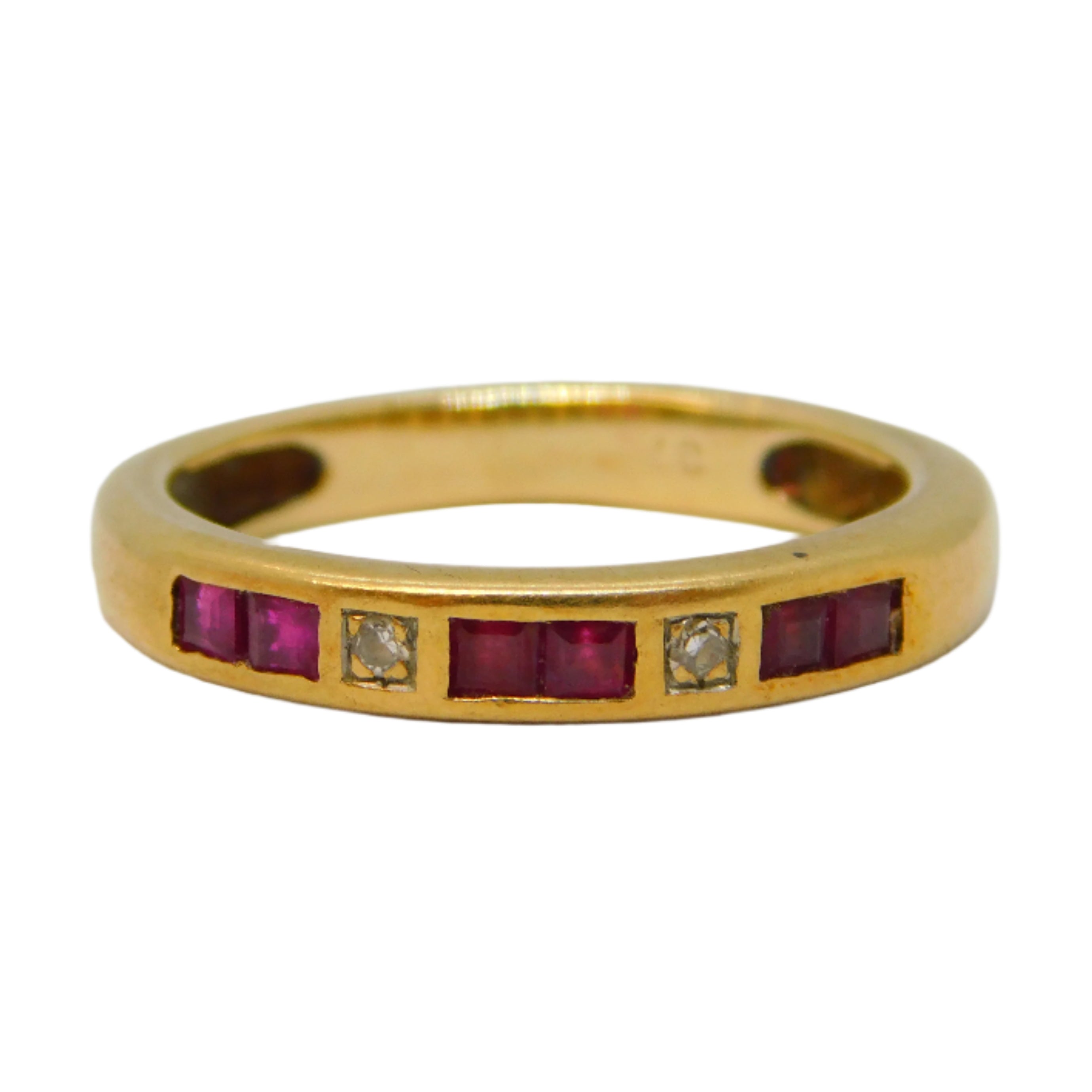 Gold ring with embedded red stones and a diamond on a light gray background