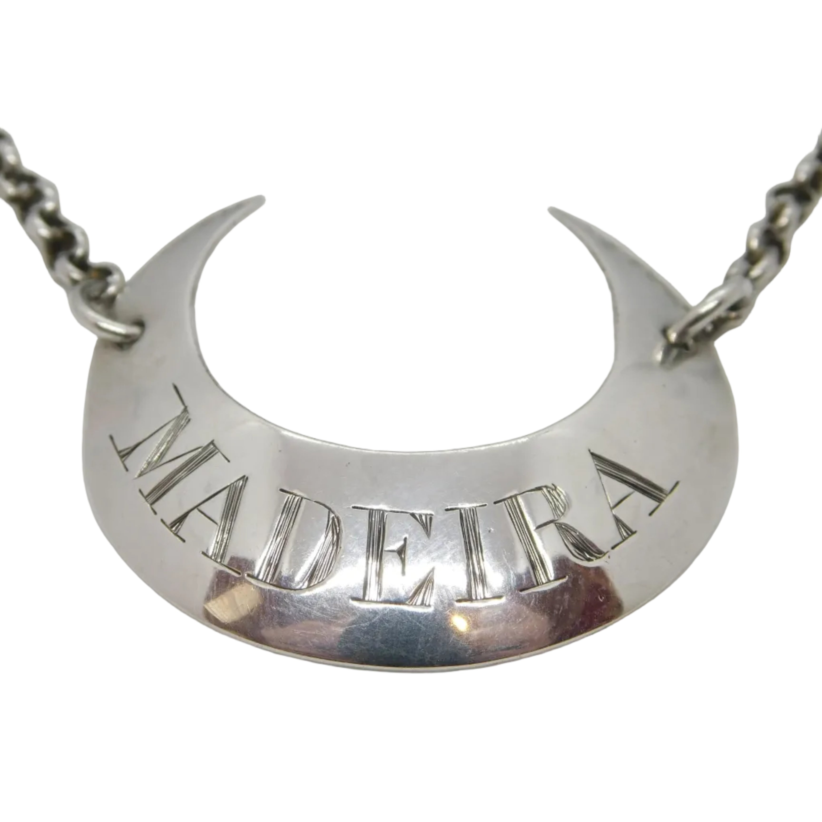 An antique Georgian sterling silver crescent-shaped decanter label with 'MADDIRA' engraved on it, featuring a bright cut design and a chain for attachment.