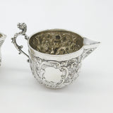 Pair Victorian Sterling Silver Cupid, Floral, Mythic Cream Jugs Antique 1900