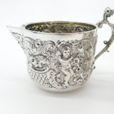 Pair Victorian Sterling Silver Cupid, Floral, Mythic Cream Jugs Antique 1900