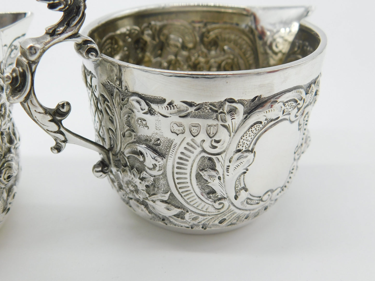 Pair Victorian Sterling Silver Cupid, Floral, Mythic Cream Jugs Antique 1900