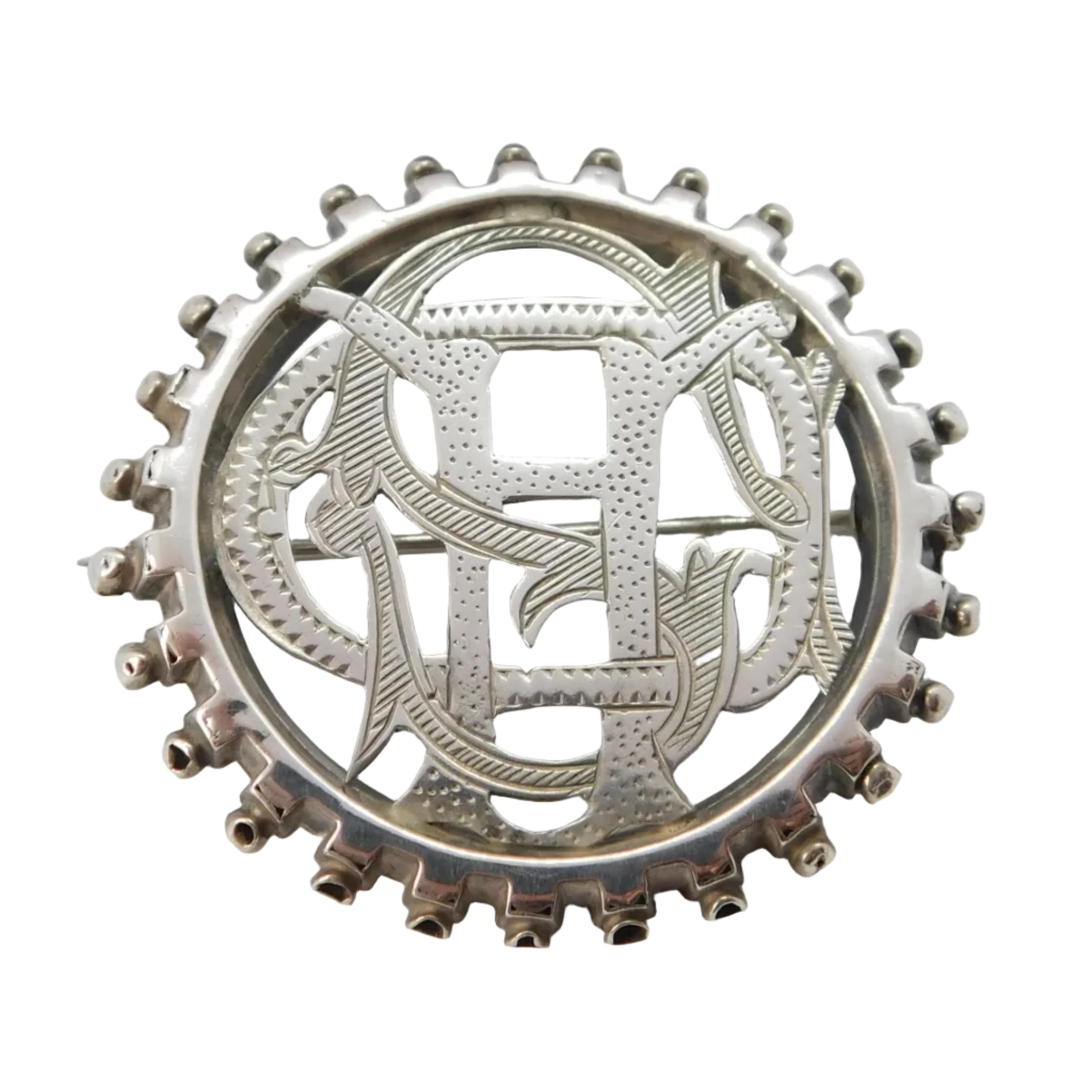 A Victorian sterling silver 'CHS' monogram sweetheart brooch displayed in front of its open box, which is not included in the sale.