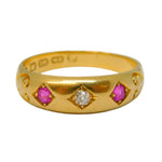 Gold ring with pink gemstones and a diamond on a light gray background