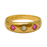Gold ring with pink gemstones and a diamond on a light gray background