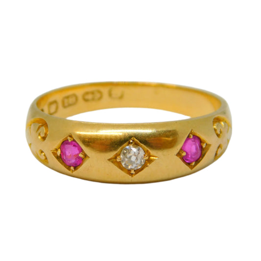 Gold ring with pink gemstones and a diamond on a light gray background