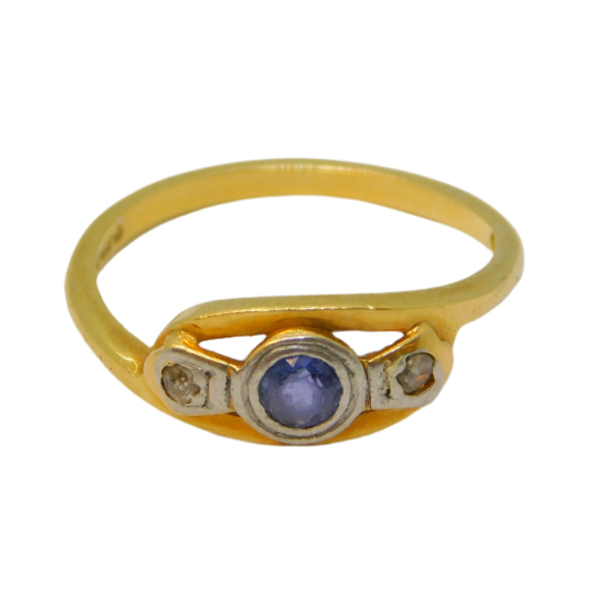 Gold ring with a central gemstone on a white background