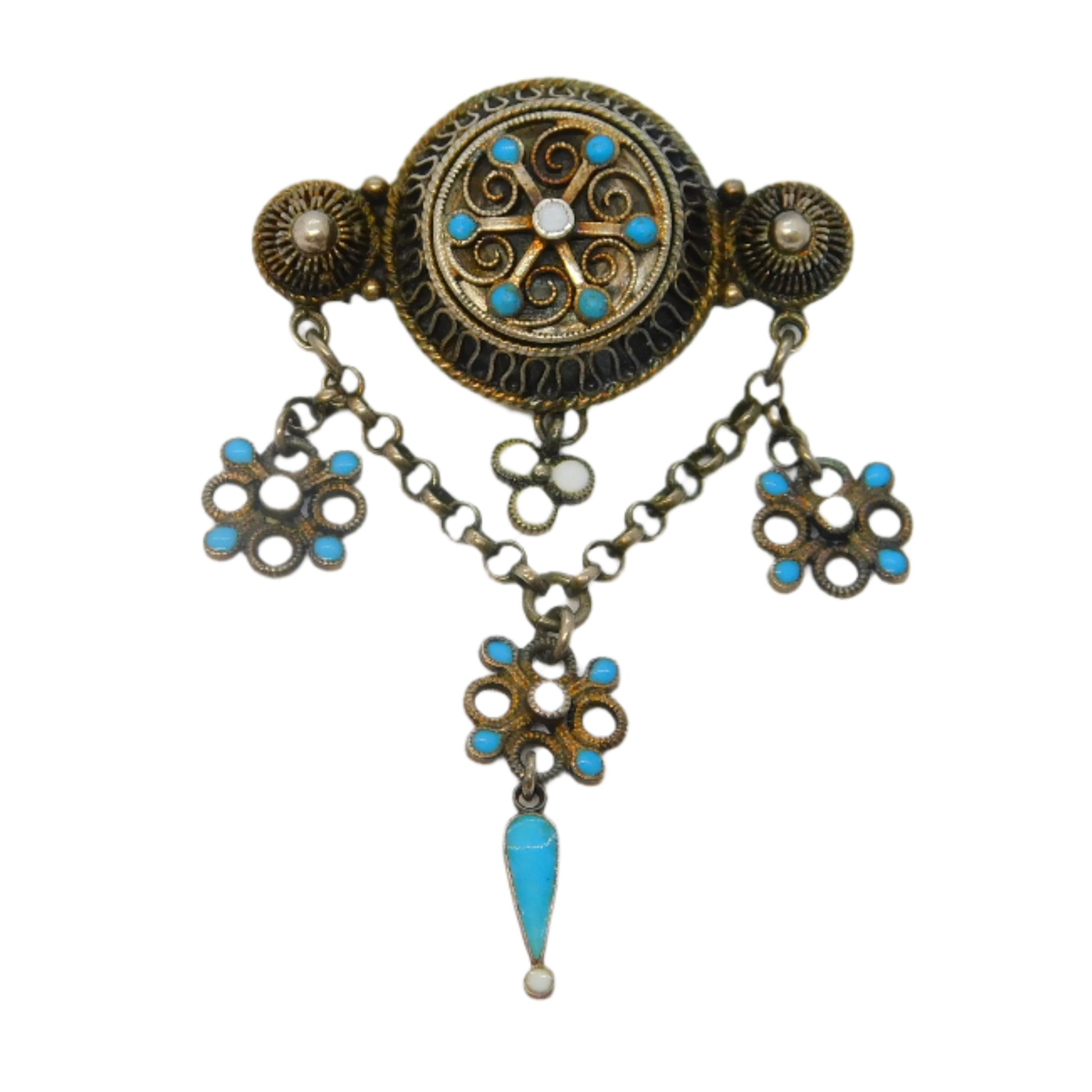 Decorative brooch with turquoise stones and floral designs on a white background