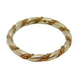 Gold ring with a twisted design on a light gray background