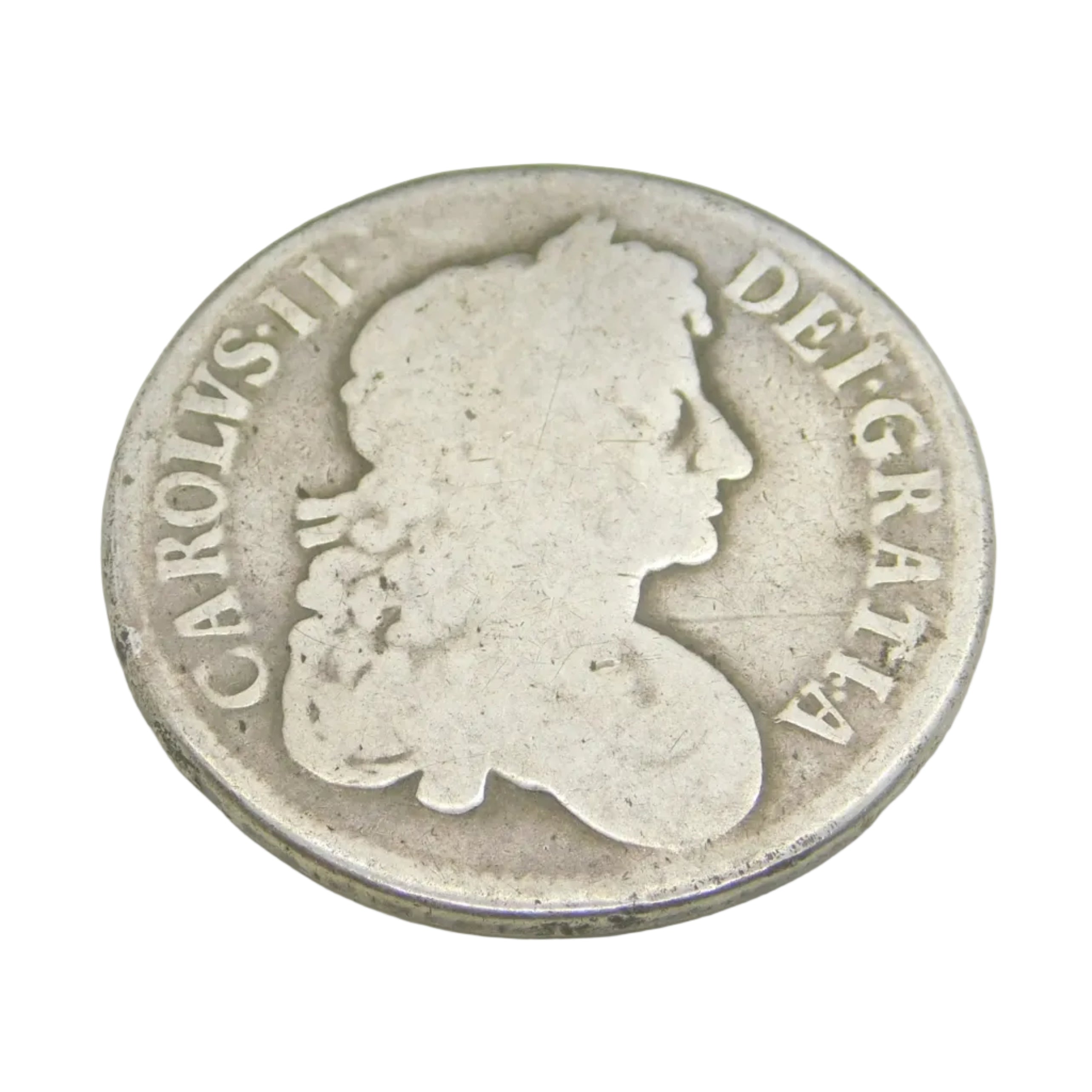 An antique King Charles II sterling silver crown coin from 1677, displayed in front of a blue-lined box, with the date below the portrait of the king.